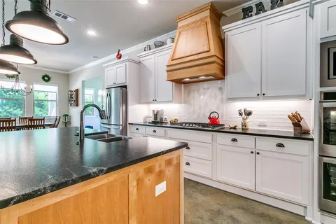 a kitchen with stainless steel appliances granite countertop a sink dishwasher and cabinets with wooden floor