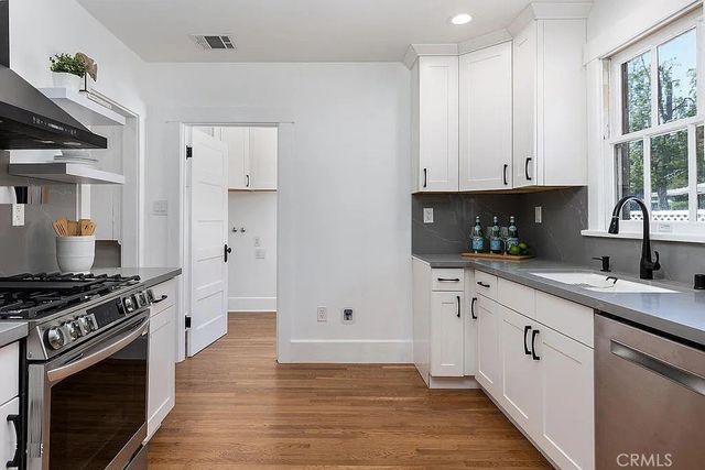 a kitchen with stainless steel appliances a sink stove and cabinets