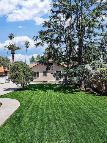 a view of a house with a big yard and a large tree