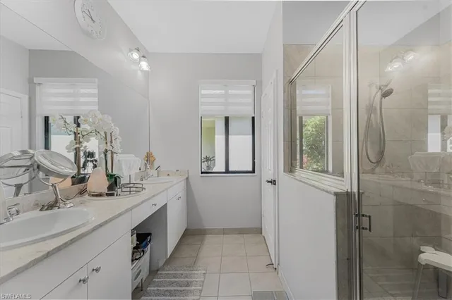 a bathroom with a double vanity sink a mirror and a shower