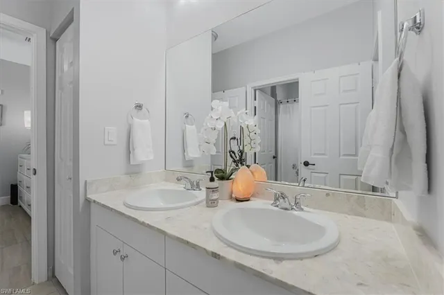 a bathroom with double sink and a mirror