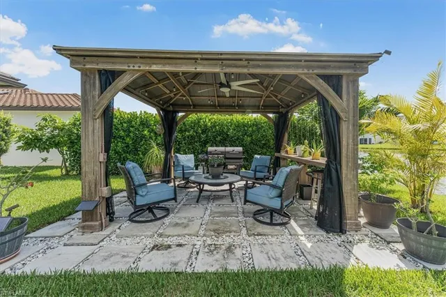 a view of patio with table and chairs potted plants with floor to ceiling window