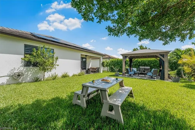 a backyard of a house with table and chairs