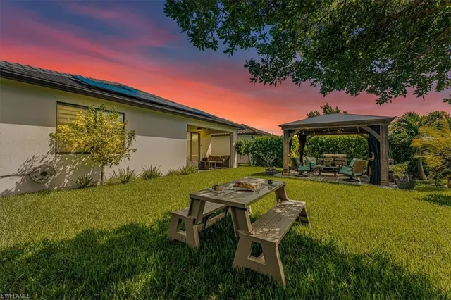a backyard of a house with table and chairs