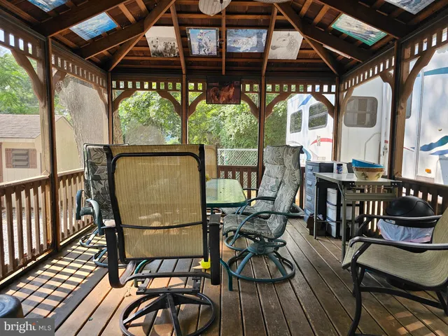 a view of a chairs and table in the patio and a wooden deck
