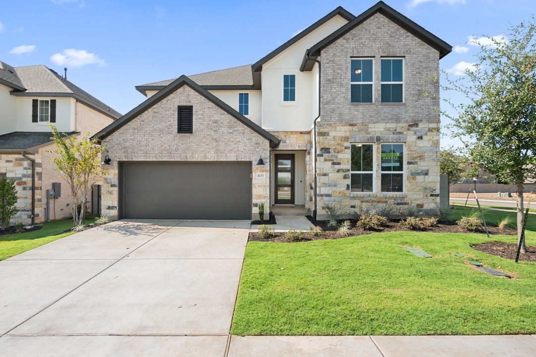 a front view of a house with a yard and garage