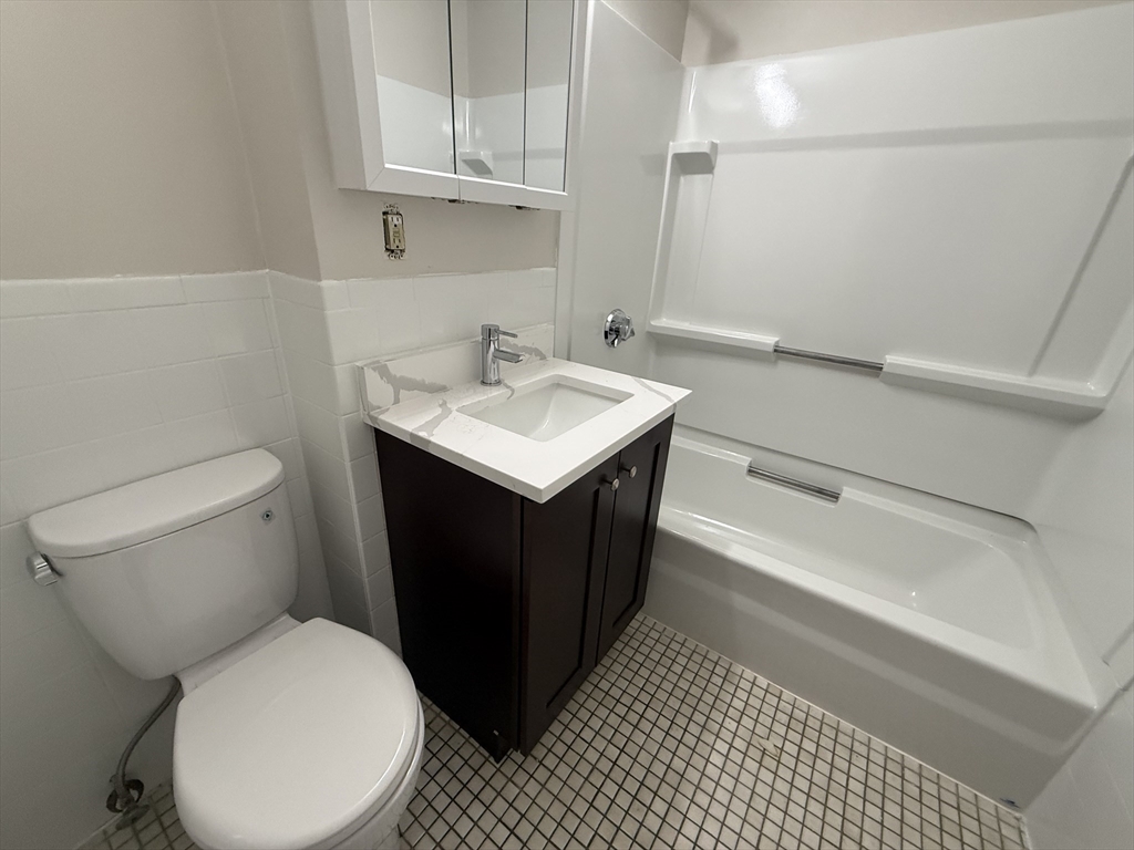 39 Newhall Street, Unit 20 Lynn, MA 01902 - Photo 11 of 11 a bathroom with a sink toilet vanity and tub