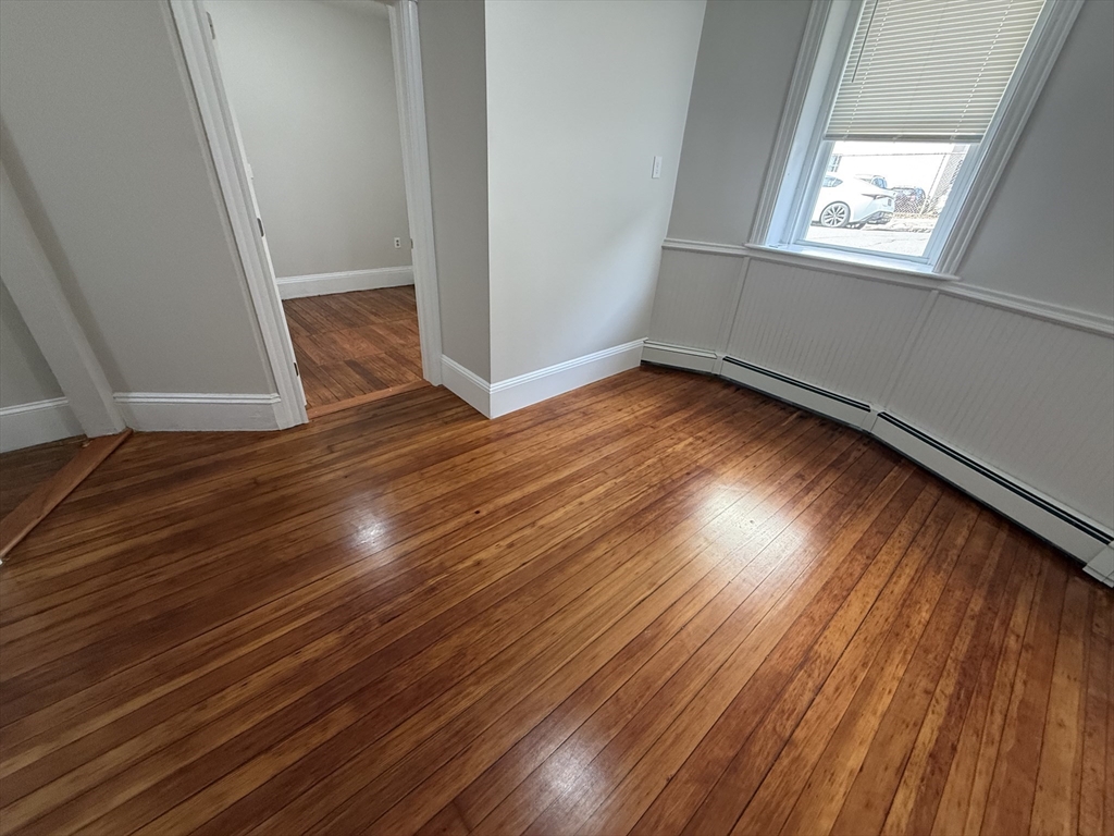 39 Newhall Street, Unit 20 Lynn, MA 01902 - Photo 4 of 11 an empty room with wooden floor and windows