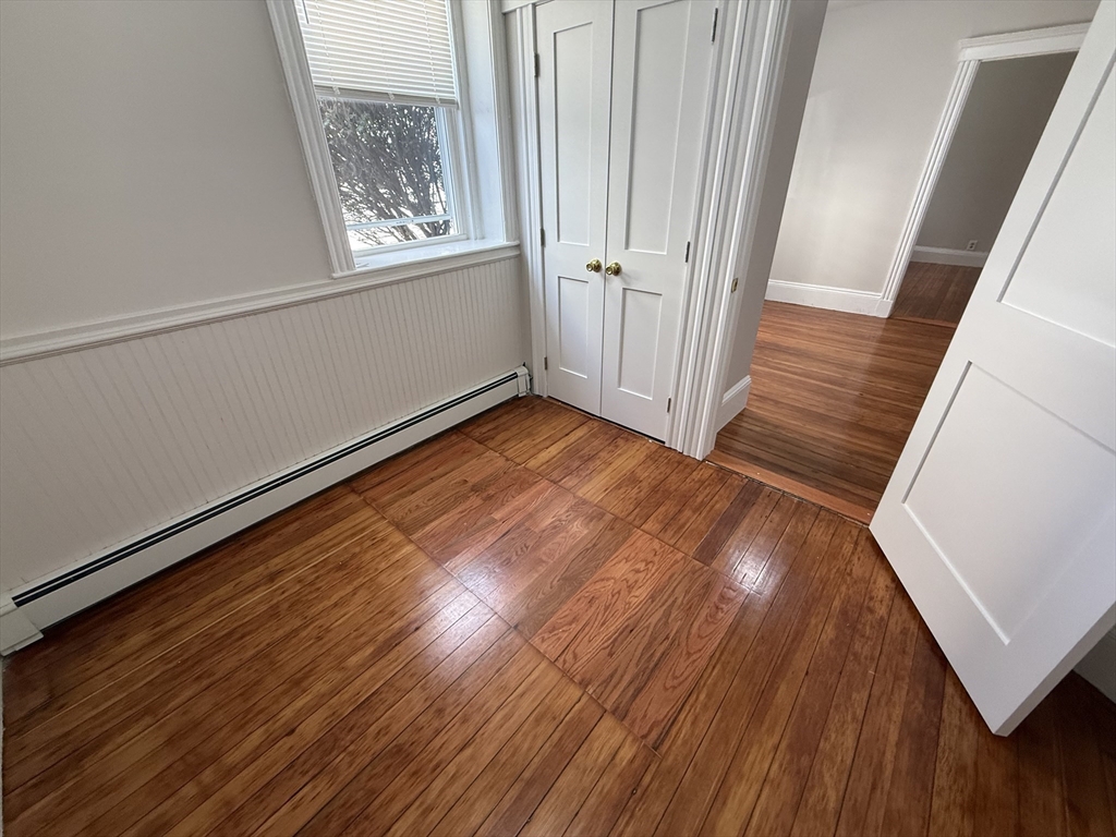 39 Newhall Street, Unit 20 Lynn, MA 01902 - Photo 6 of 11 a view of an empty room with wooden floor and a window