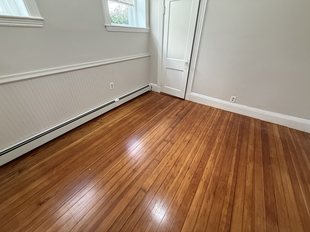39 Newhall Street, Unit 20 Lynn, MA 01902 - Photo 7 of 11 a view of an empty room with wooden floor and a window