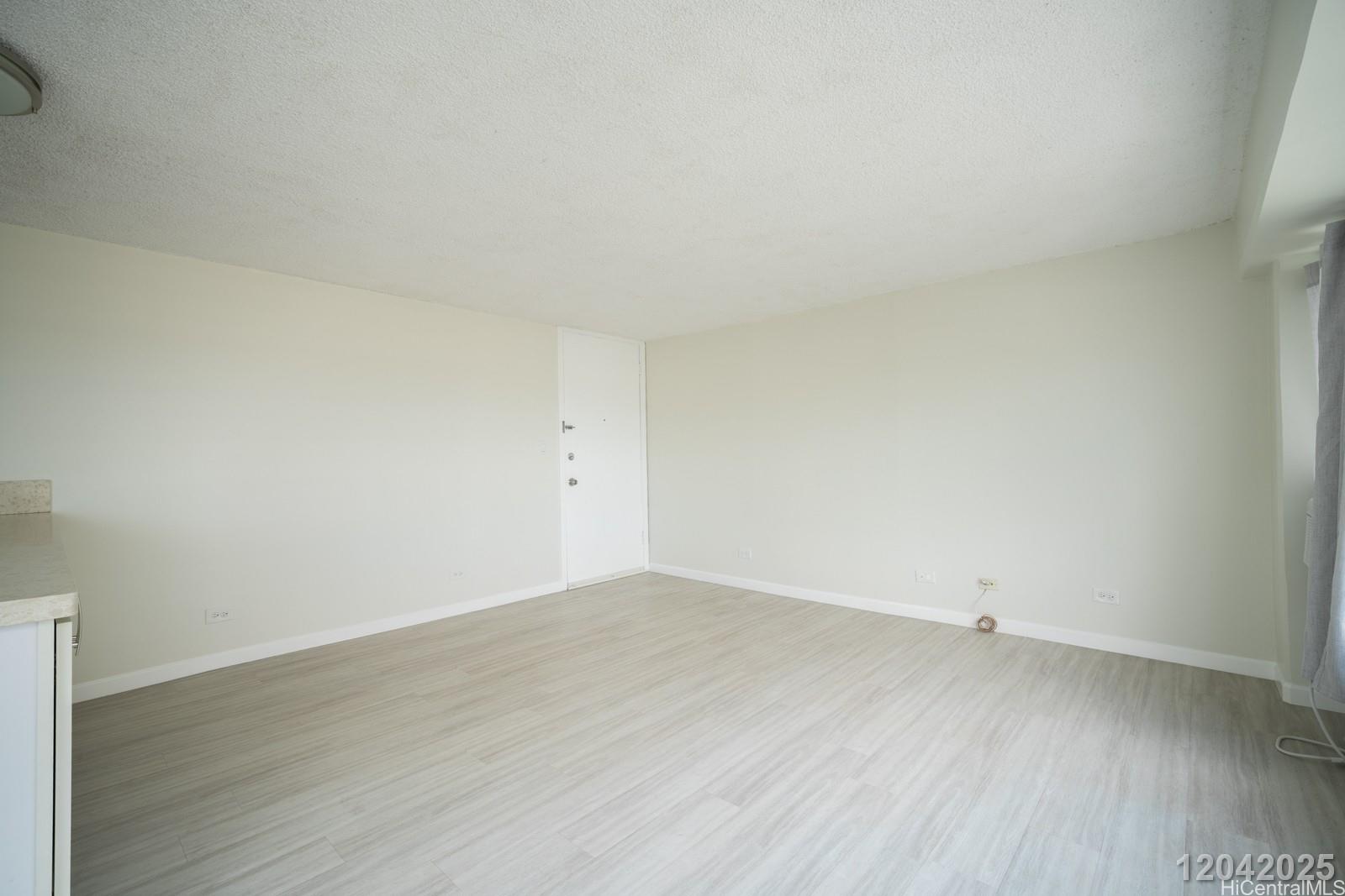 2525 Date Street, Unit 2405 Honolulu, HI 96826 - Photo 4 of 14 an empty room with wooden floor