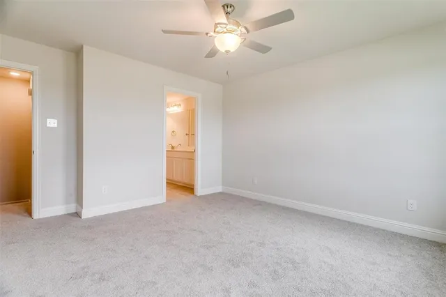 an empty room with closet and a ceiling fan