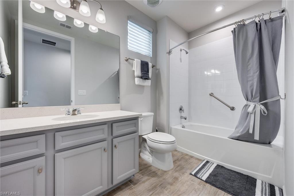 4607 Arboretum Circle, Unit 103 Naples, FL 34112 - Photo 16 of 29 a bathroom with a granite countertop sink toilet and shower