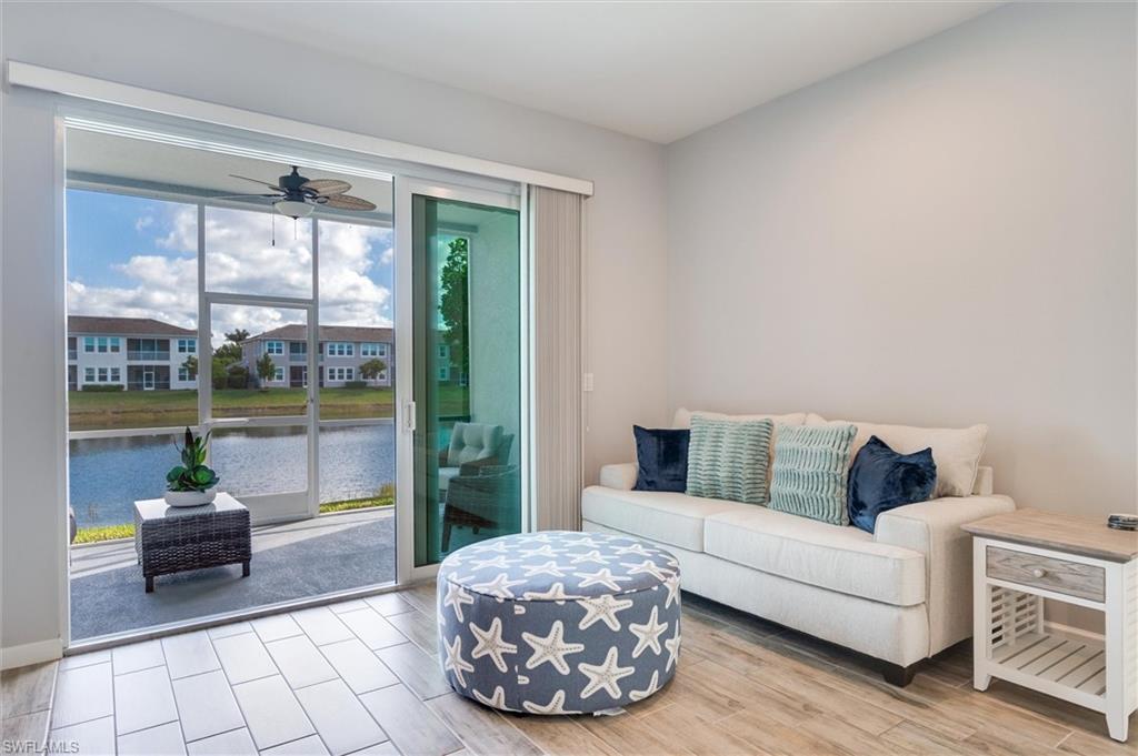 4607 Arboretum Circle, Unit 103 Naples, FL 34112 - Photo 5 of 29 a living room with furniture and a floor to ceiling window