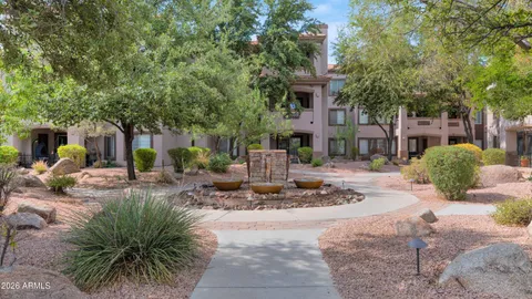 a living room with furniture kitchen view and a chandelier
