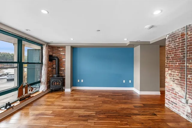 a view of empty room with wooden floor and fireplace