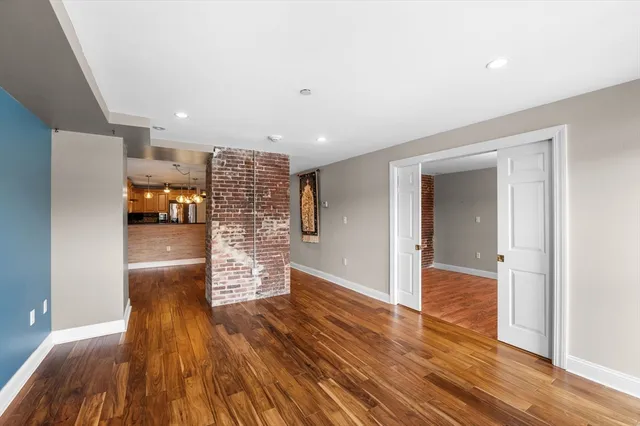 a kitchen with stainless steel appliances granite countertop a refrigerator a sink dishwasher a stove and white countertops with wooden floor