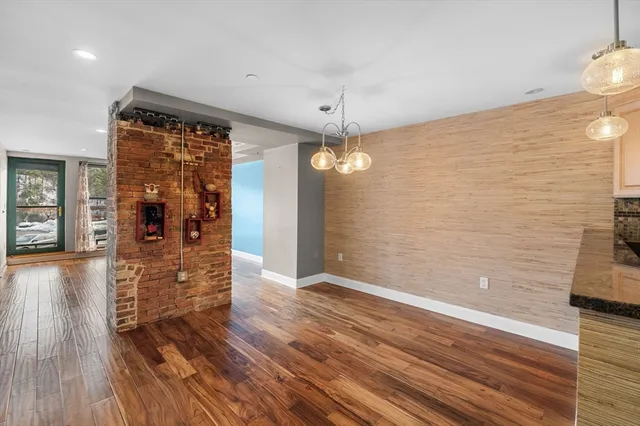 a view of a hallway with wooden floor and a chandelier