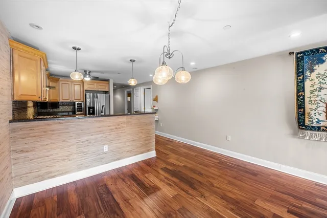 a view of a hallway with wooden floor and closet