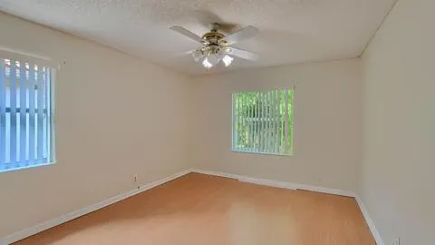 an empty room with closet and ceiling fan
