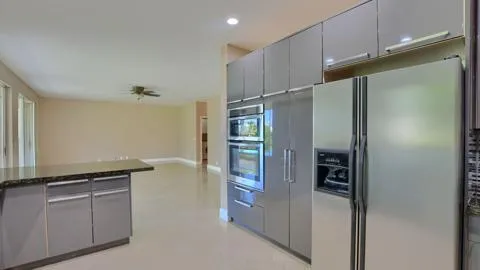 a kitchen with granite countertop cabinets and refrigerator