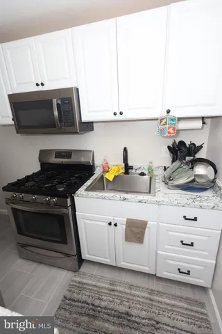 a kitchen with a stove and white cabinets