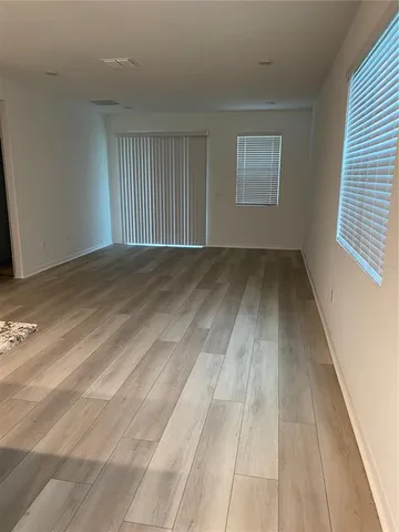 a view of a room with wooden floor and window