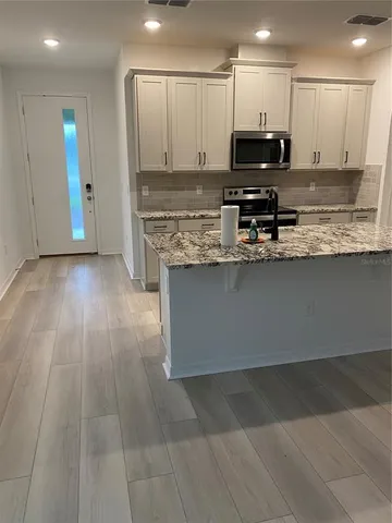 a kitchen with stainless steel appliances granite countertop a stove a sink and a microwave