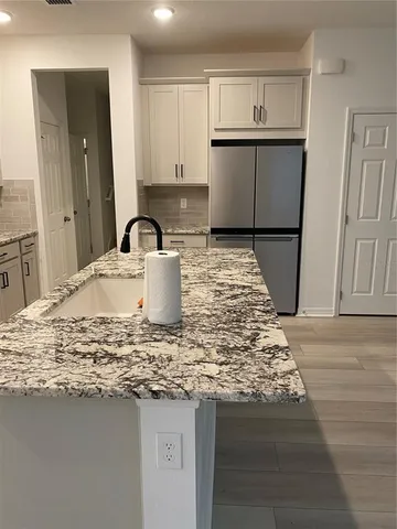 a kitchen with kitchen island granite countertop a sink and a stove