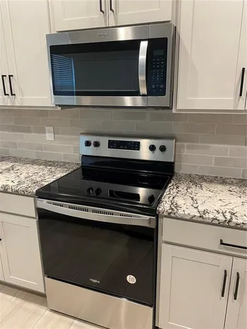 a stove top oven sitting inside of a kitchen