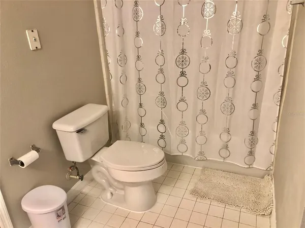 a white toilet sitting next to a shower curtain