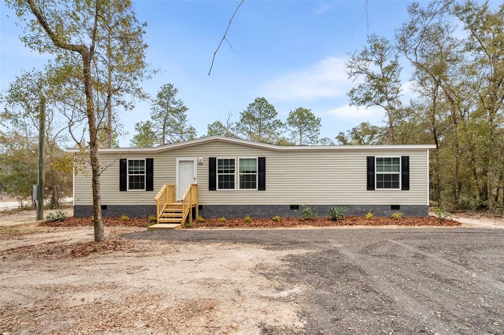 7591 Northeast 90 Avenue Bronson, FL 32621 - Photo 1 of 1 a backyard of a house with barbeque oven and a tree