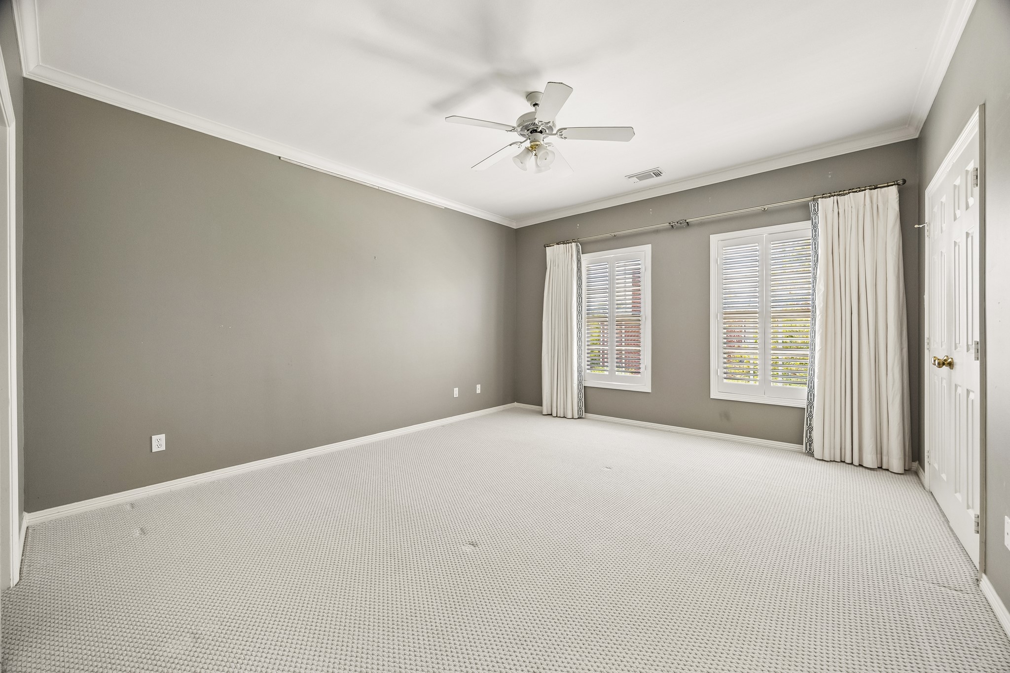 6022 Burgoyne Road Houston, TX 77057 - Photo 18 of 30 Expansive bedroom with neutral finishes, crown molding, and large windows creating a bright, relaxing retreat.