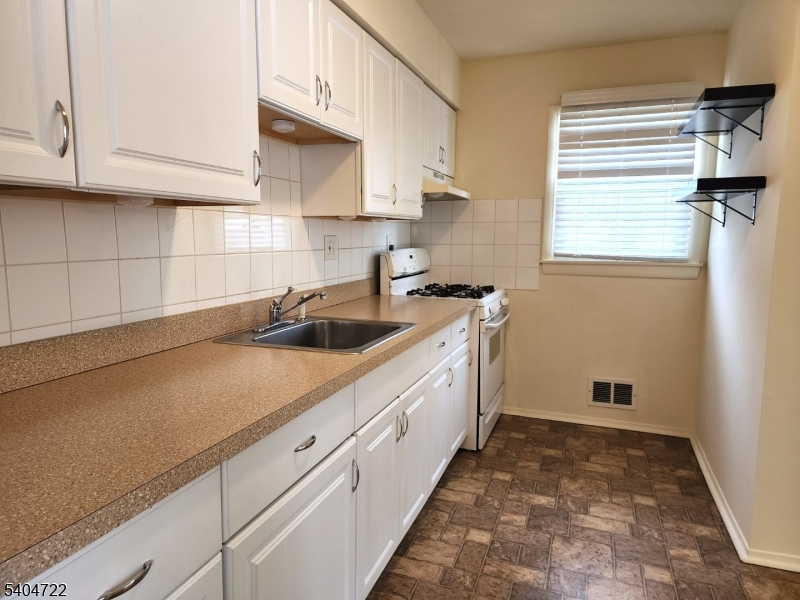 19 Grove Street, Unit B Wanaque, NJ 07465 - Photo 9 of 24 a kitchen with sink cabinets and window
