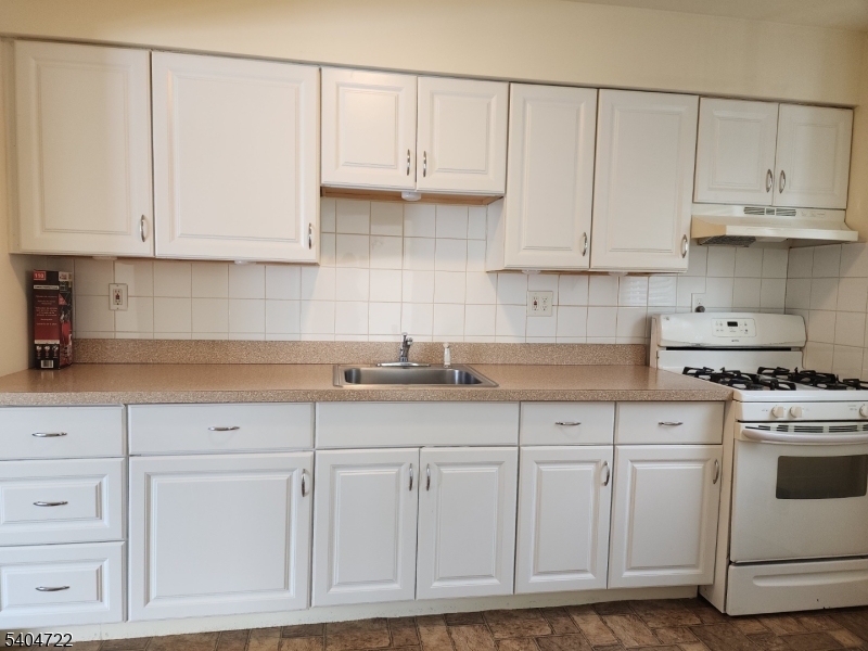 19 Grove Street, Unit B Wanaque, NJ 07465 - Photo 10 of 24 a kitchen with white cabinets and white appliances