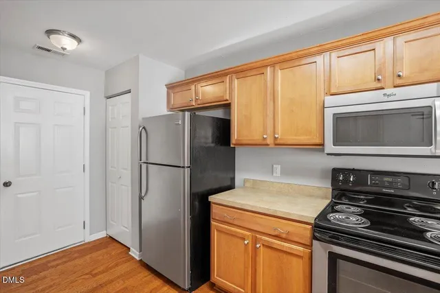 a kitchen with stainless steel appliances granite countertop white cabinets and a stove top oven