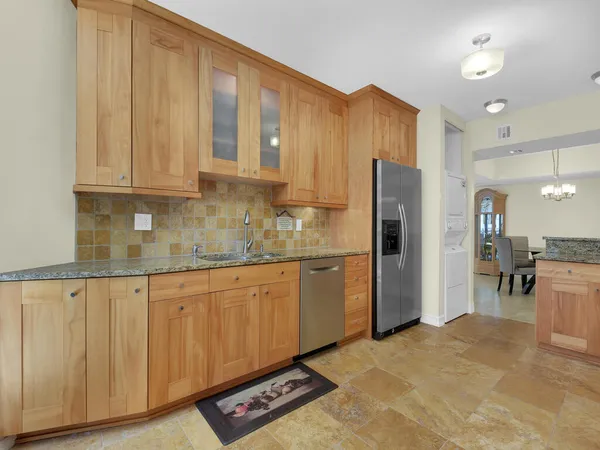 a kitchen with stainless steel appliances granite countertop a refrigerator and cabinets