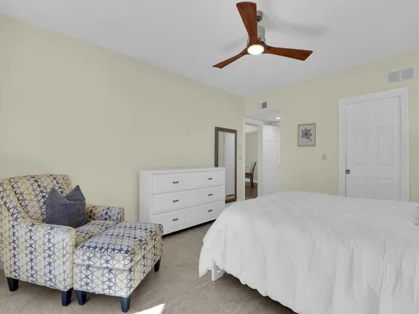 a bedroom with a bed a chandelier and a dresser