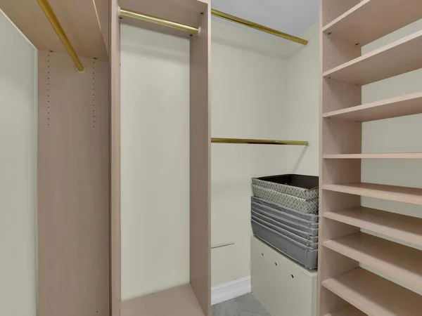 a view of walk in closet with empty racks
