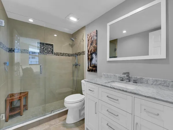 a bathroom with a granite countertop sink toilet and shower