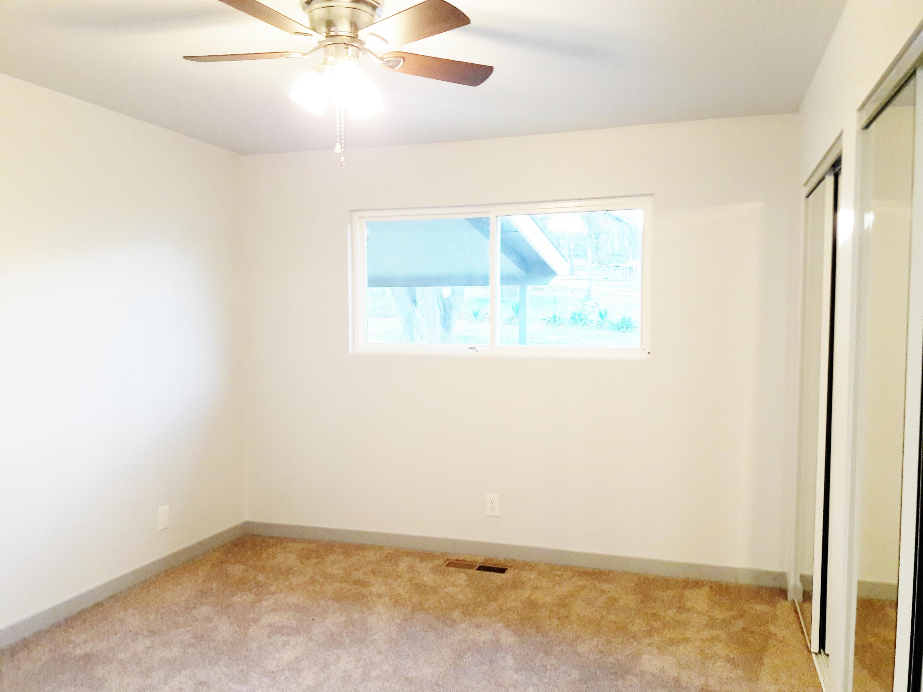 1610 Canyon Road Redding, CA 96001 - Photo 18 of 41 an empty room with a window and a ceiling fan