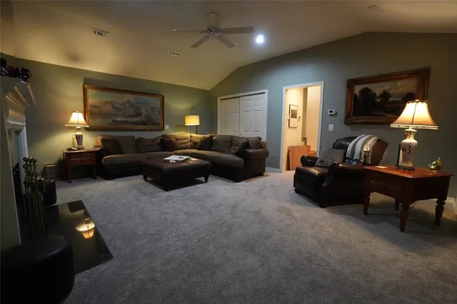 a living room with furniture a lamp and a flat screen tv
