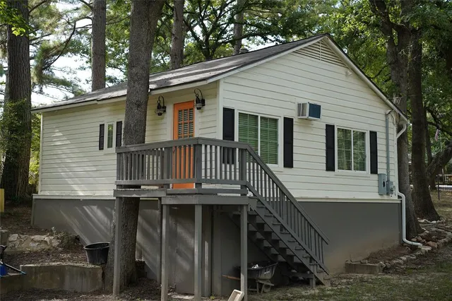 a view of house with a deck and a large window