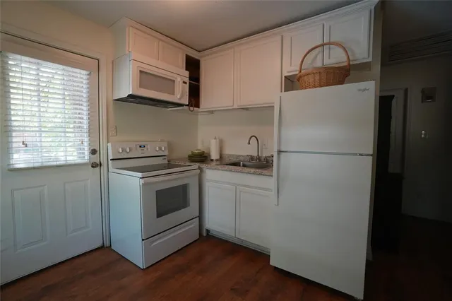 a kitchen with white cabinets and white appliances