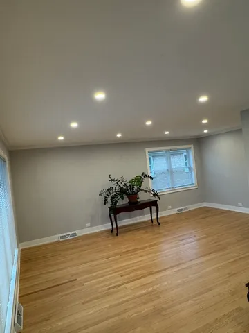 a view of a room with wooden floor and furniture