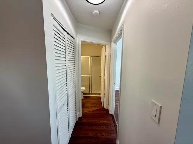 a view of a hallway with a livingroom and a bathroom with sink