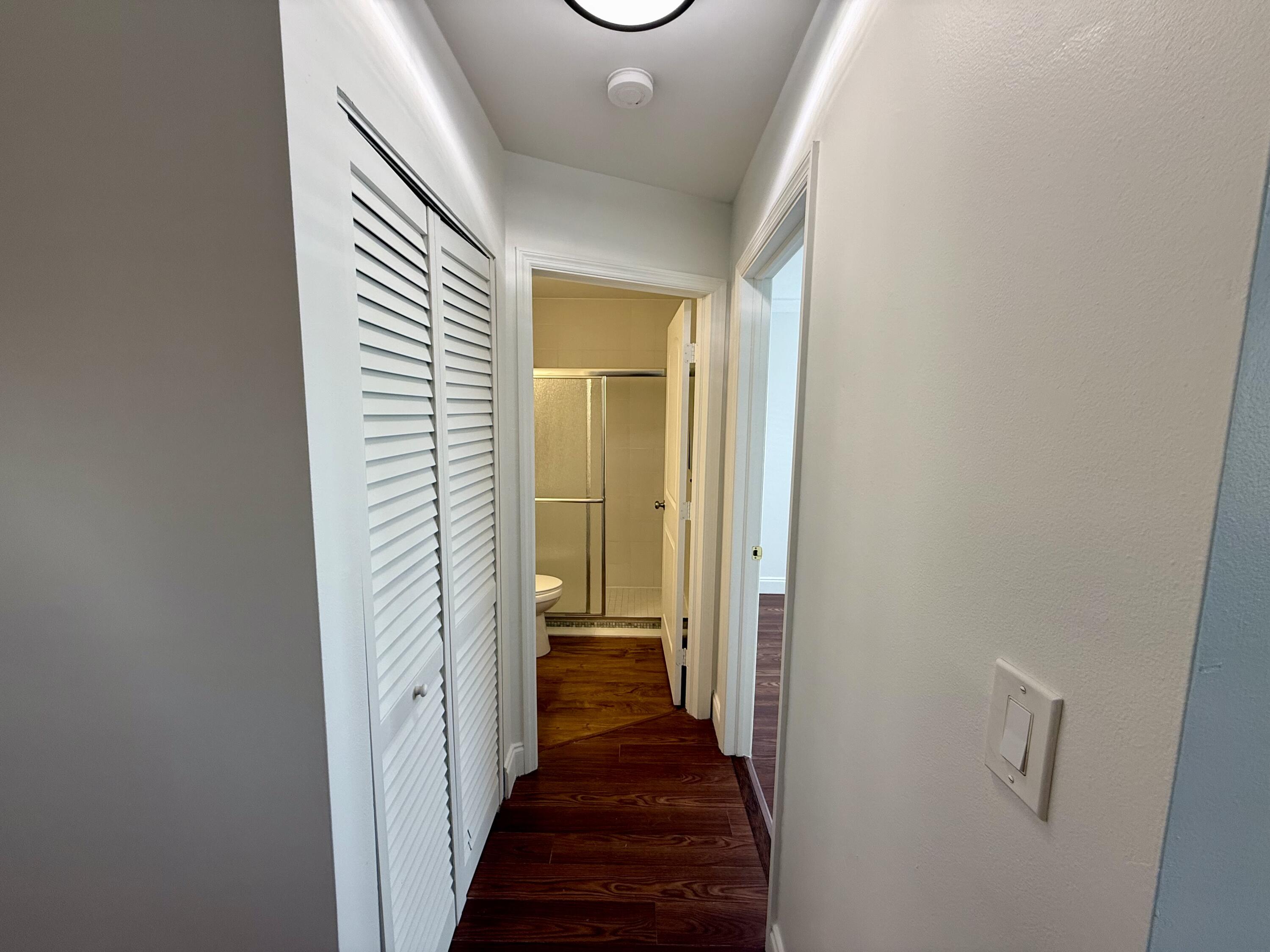 9503 Boca Cove Circle, Unit 610 Boca Raton, FL 33428 - Photo 4 of 16 a view of a hallway with a livingroom and a bathroom with sink