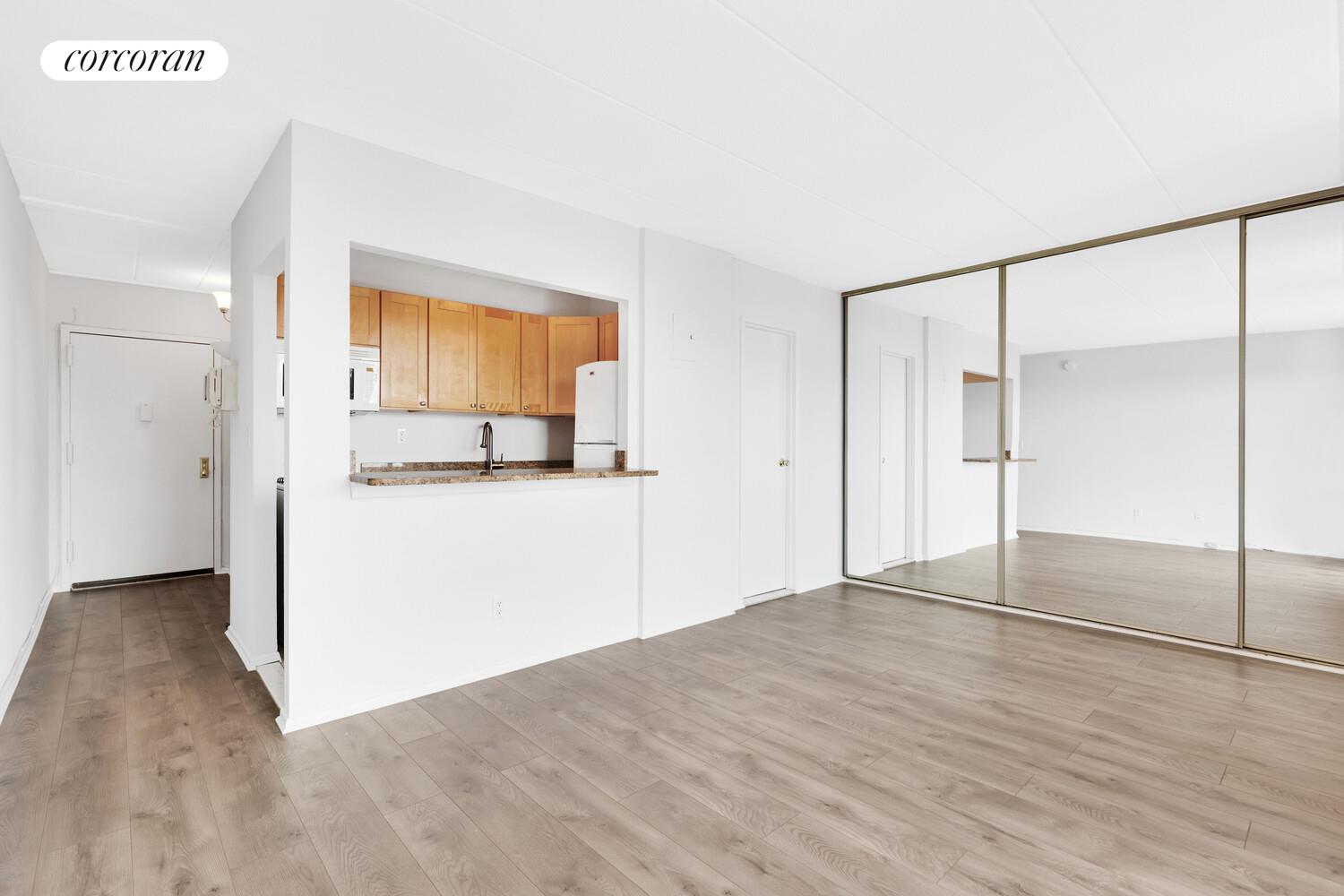23-22 30th Road, Unit 8G Queens, NY 11102 - Photo 5 of 11 a view of empty room with wooden floor and cabinet