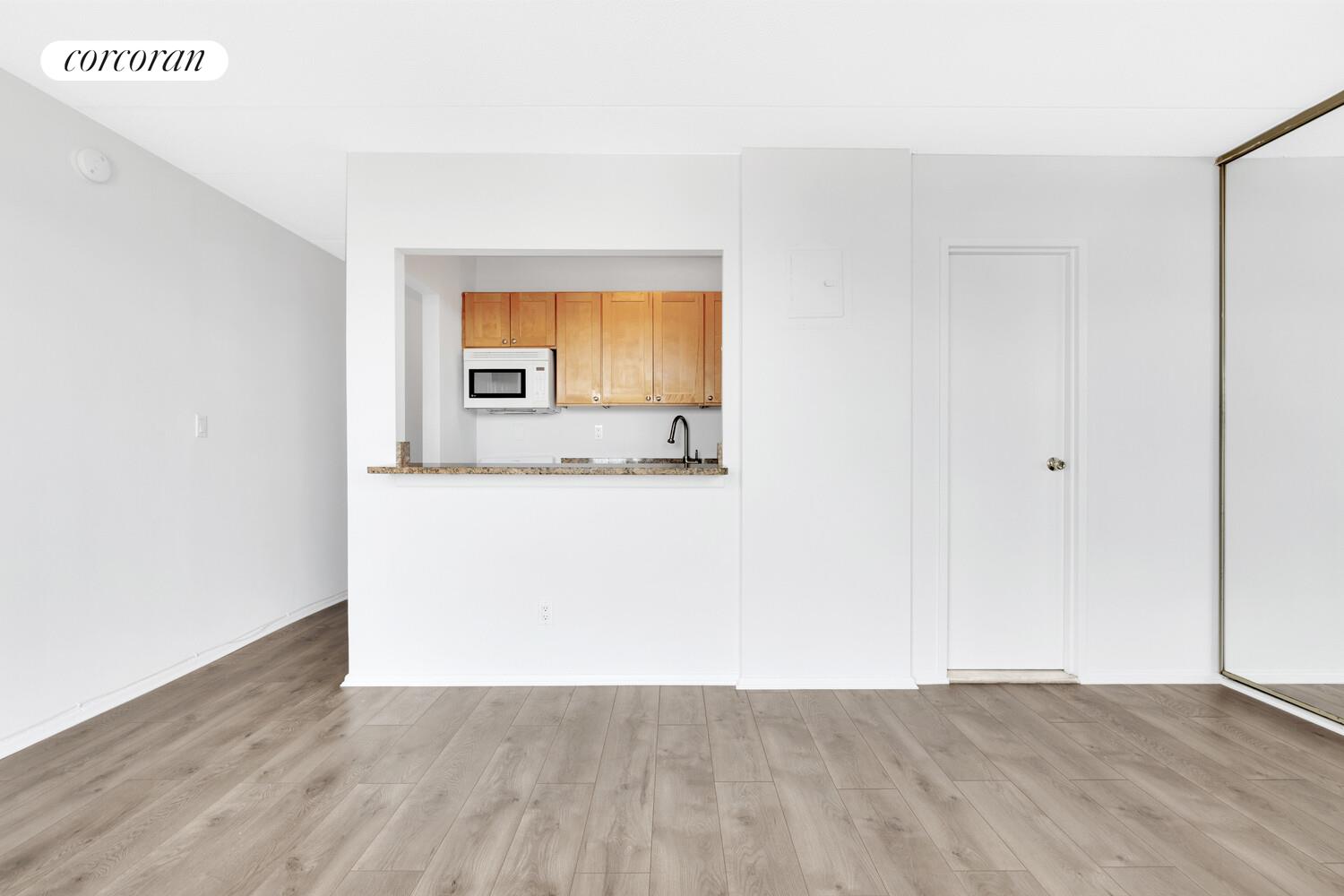 23-22 30th Road, Unit 8G Queens, NY 11102 - Photo 6 of 11 a view of a room with wooden floor and cabinet