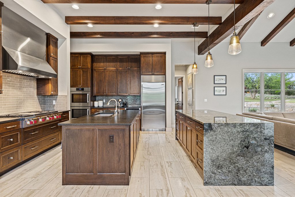 2560 Bell Springs Road Dripping Springs, TX 78620 - Photo 15 of 40 a kitchen with stainless steel appliances granite countertop a stove a sink and a refrigerator